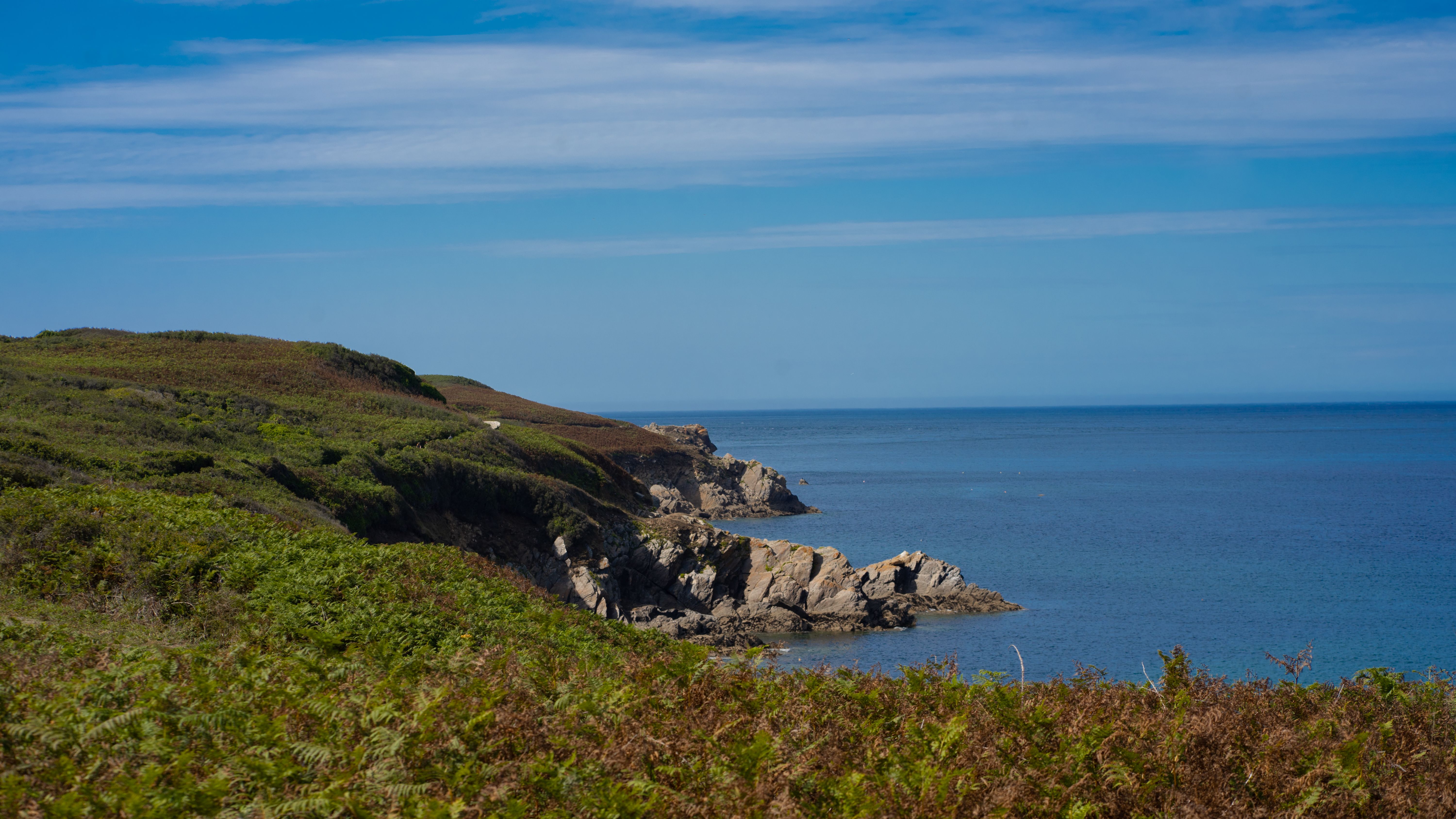 Coastal landscape with blue water and green cliffs